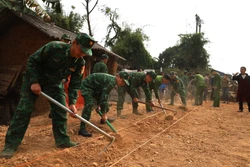 Cán bộ, chiến sĩ lực lượng vũ trang hỗ trợ xóa nhà tạm, nhà dột nát cho bà con dân tộc thiểu số trên địa bàn huyện Đồng Văn (Hà Giang). Ảnh: TXTVN